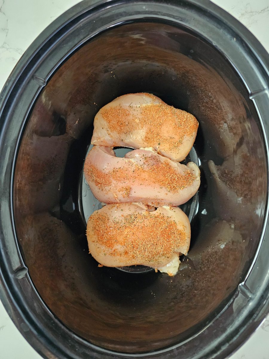 season raw chicken and place in slow cooker