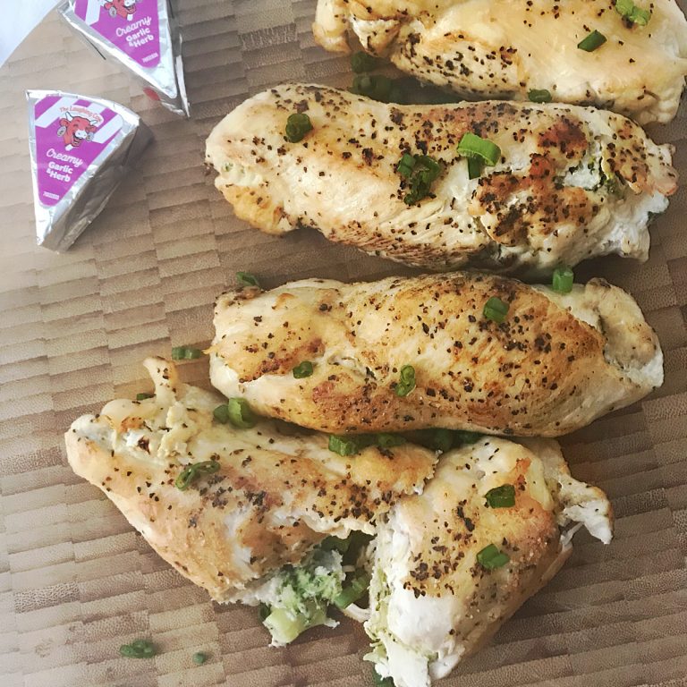 The final plated dish of Broccoli Stuffed Chicken Breasts shown with two foil-wrapped cheese wedges in the upper corner.