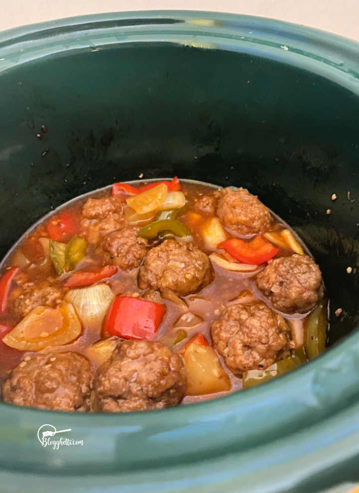 slow cooker with sweet and sour meatballs in sauce