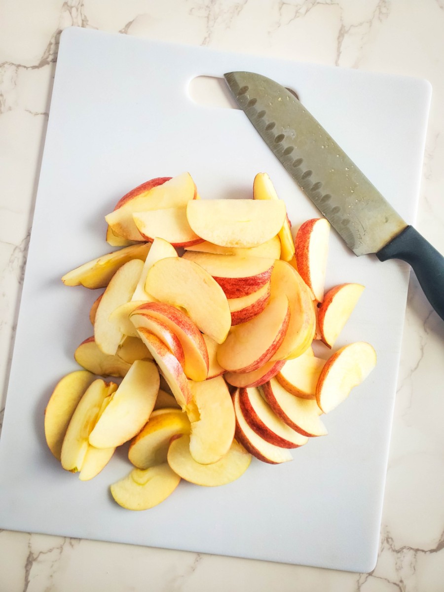slicing the apples on a white cutting board