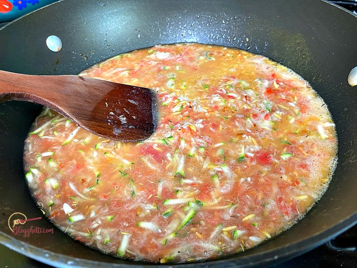 simmering the orzo, tomato and rice