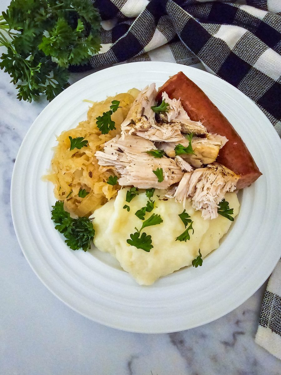 plate with pork sausage sauerkraut and mashed potatoes