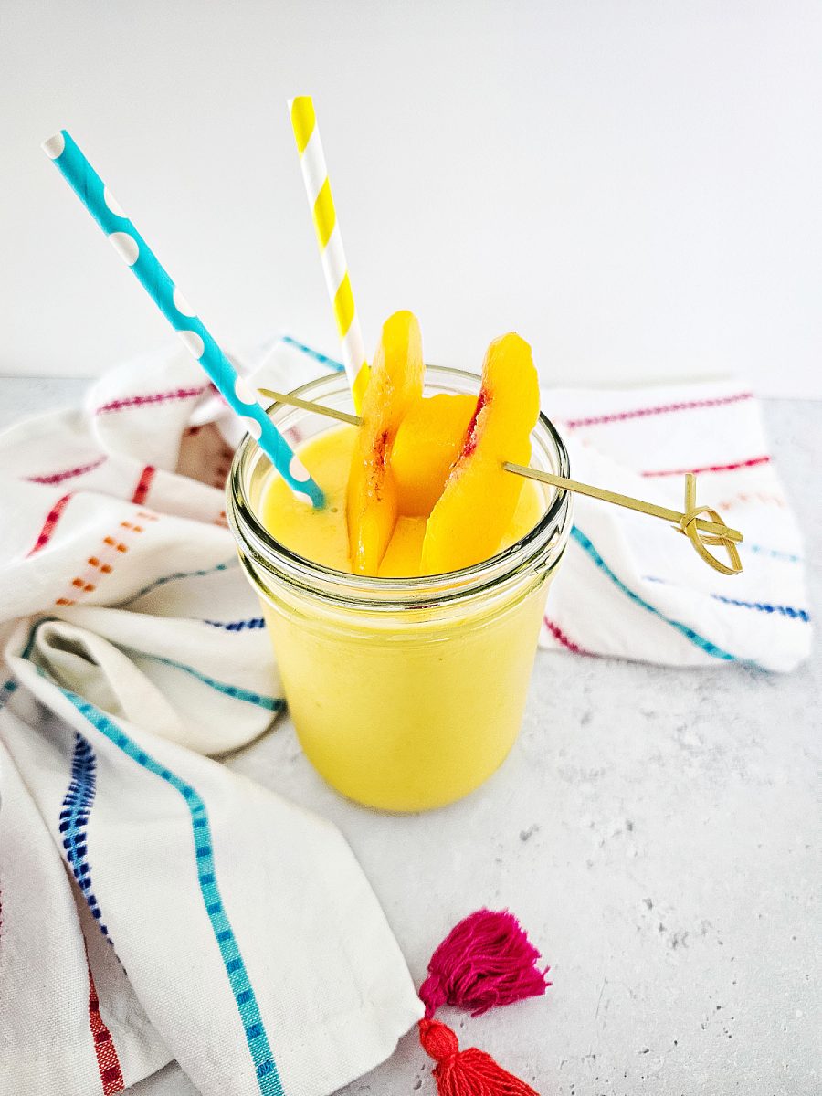 peach and mango blended drink with fruit slices