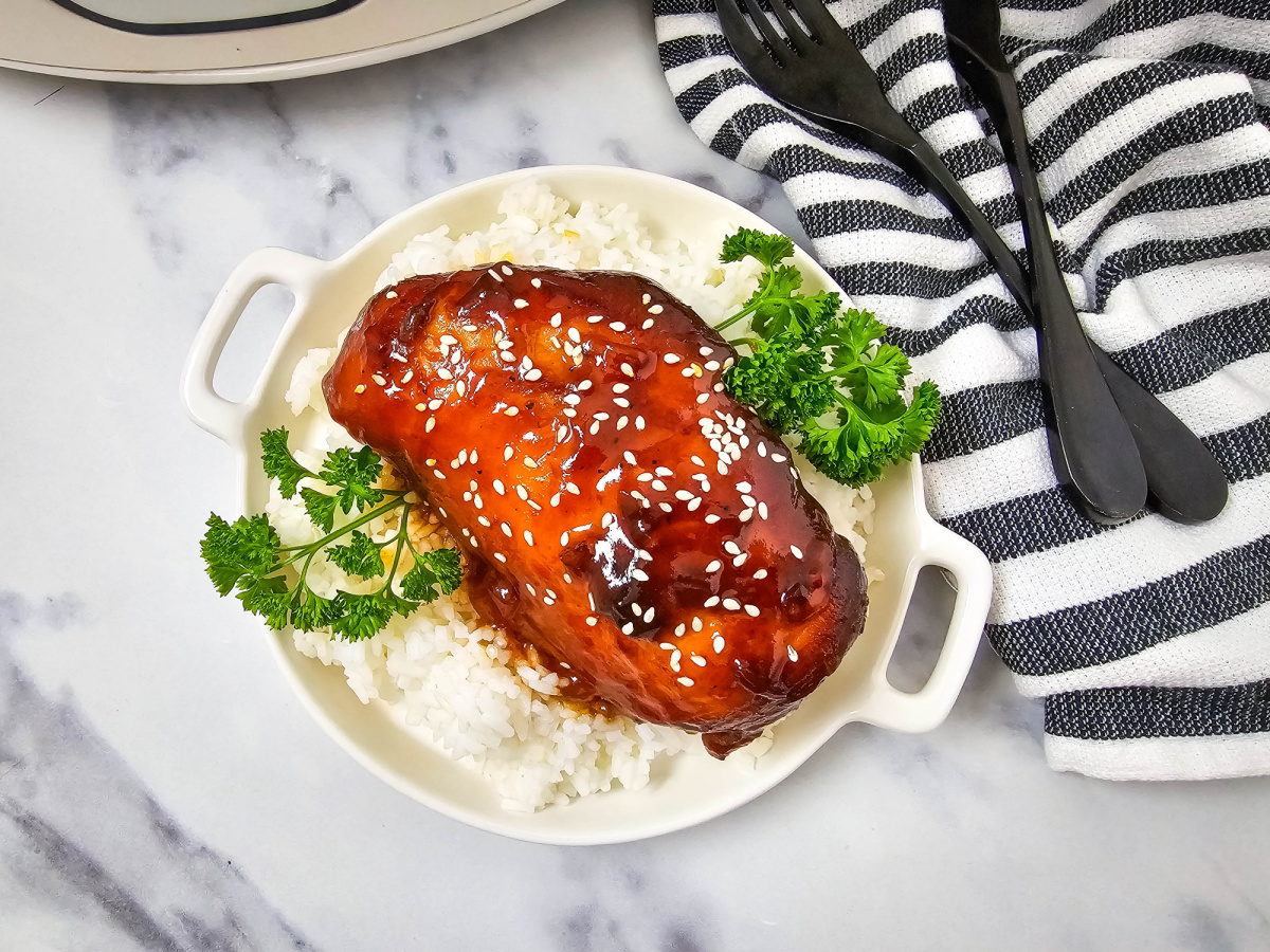glazed chicken breast over rice on plate