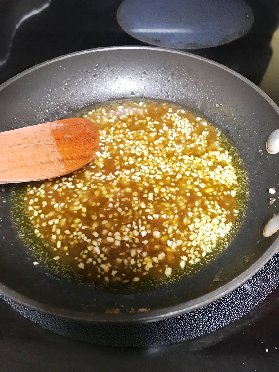 skillet with olive oil and garlic simmering