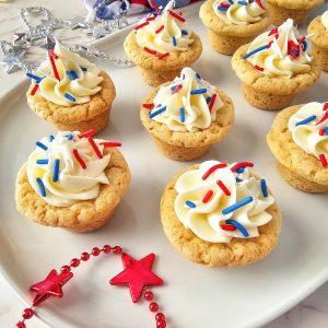 These easy-to-make bite sized Patriotic Sugar Cookie Cups are topped with festive red, white, and blue sprinkles. These delightful treats are bursting with flavor and patriotism, making them the ultimate choice for celebrating any American occasion in style.