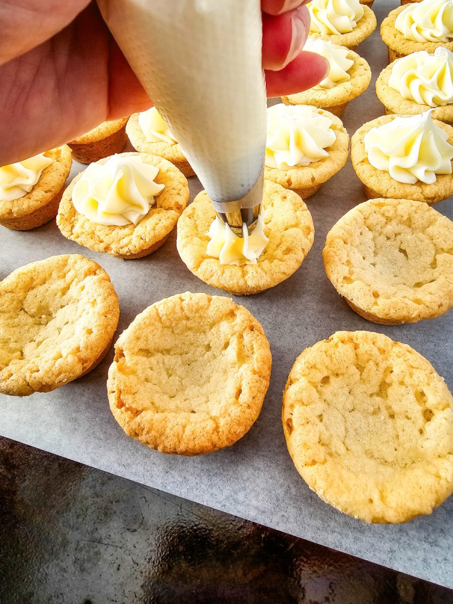 fill cookie cups with white frosting