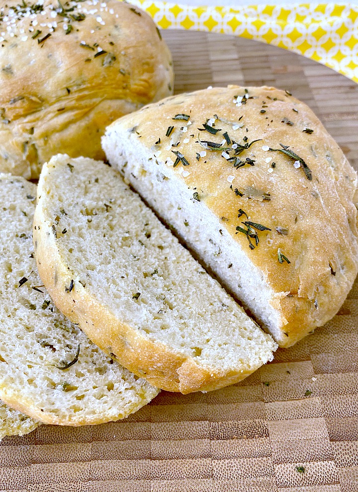 Rosemary bread sliced on wooden cutting board