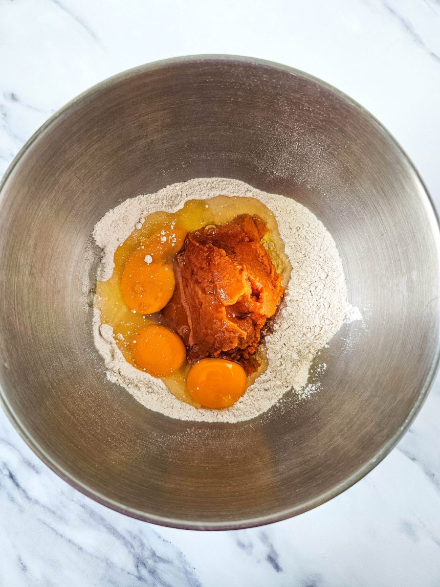 large mixing bowl with cake mix eggs and pumpkin