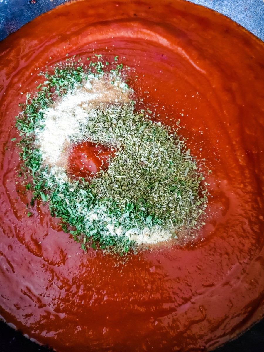 seasoning marinara sauce in skillet