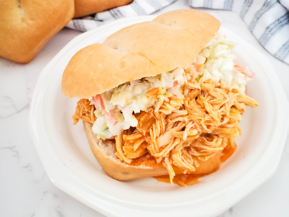 close up of buffalo chicken sandwich topped with coleslaw