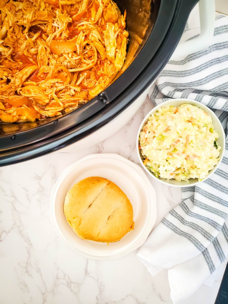 shredded buffalo chicken in slow cooker ready to serve on buns