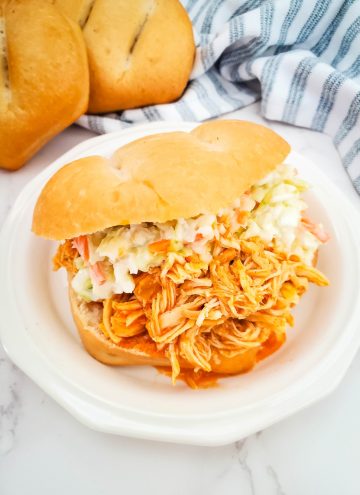 slow cooker buffalo chicken sandwich served on white plate