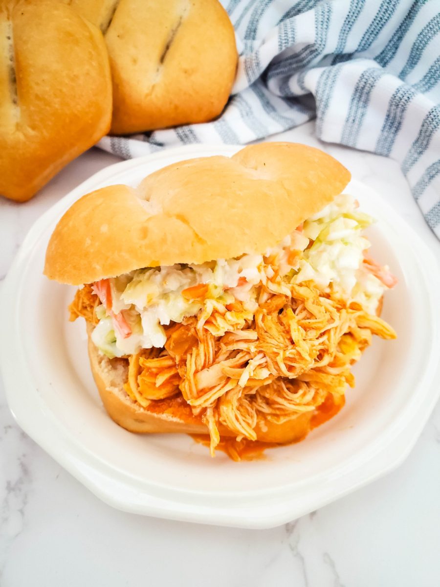 slow cooker buffalo chicken sandwich served on white plate