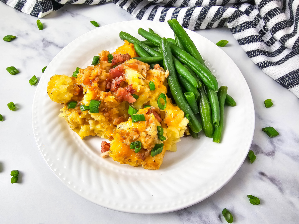 serving of potato chicken casserole with green beans on plate