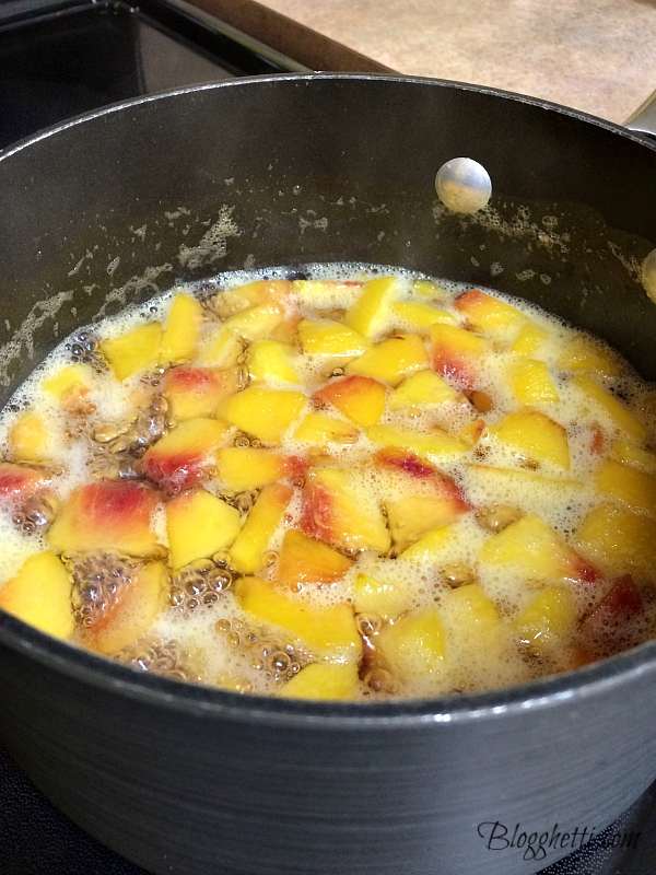 boiling saucepan with peaches, water, and sugar