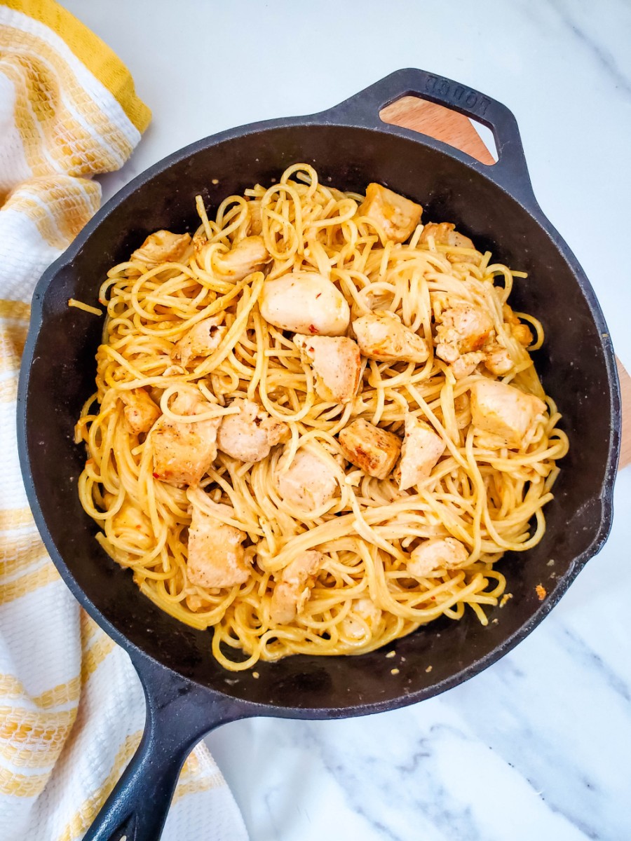 cast iron skillet with bang bang chicken pasta in it