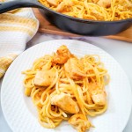 skillet and plate with chicken pasta with bang bang sauce