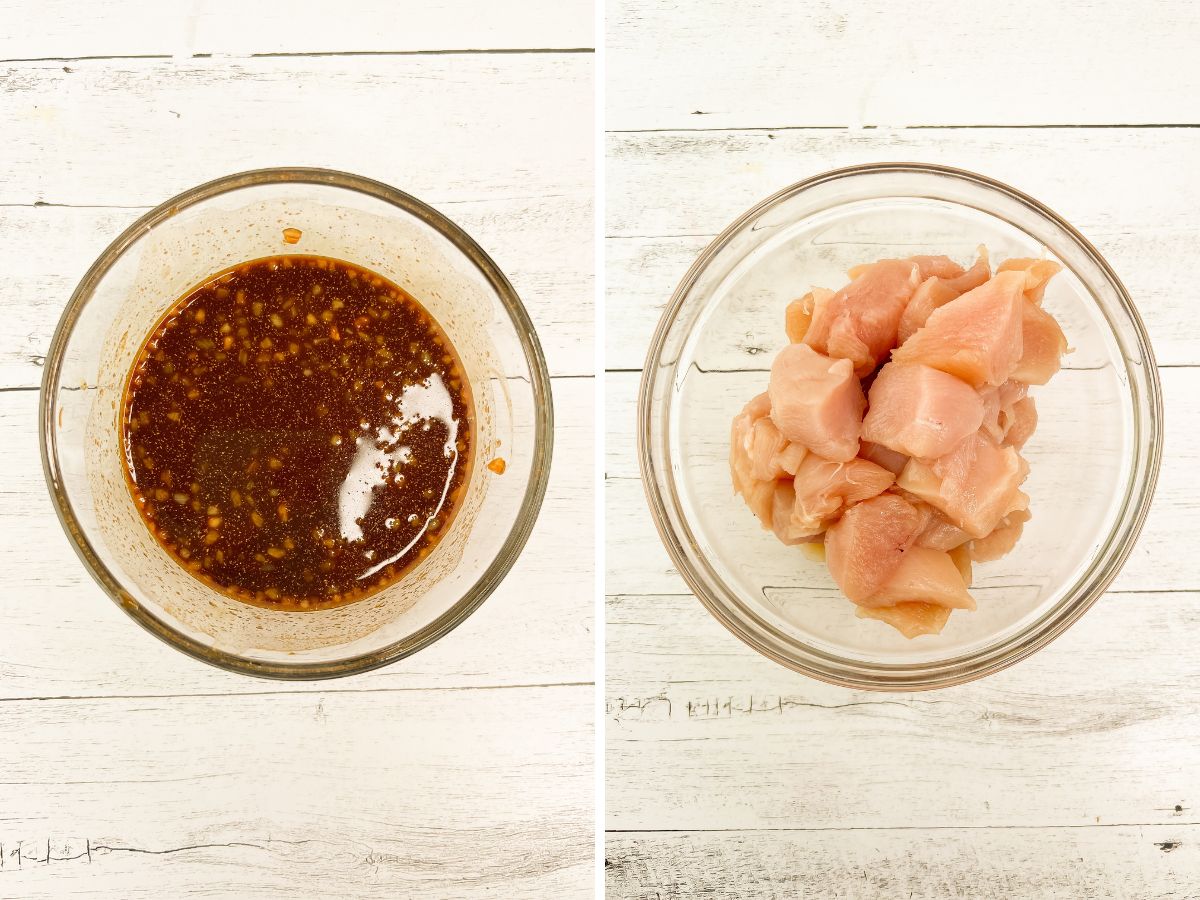 Two glass bowls on a white wooden surface. The left bowl contains a dark stir-fry sauce, and the right bowl holds cubed raw chicken pieces.