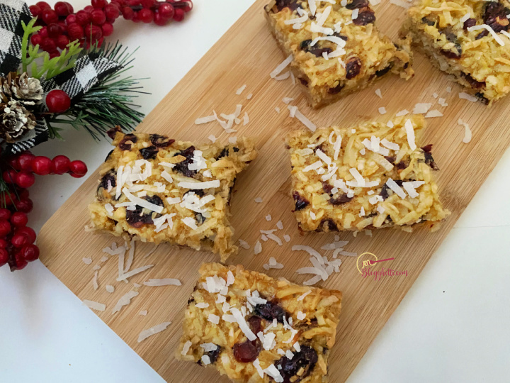 cut coconut cranberry bars on wooden tray