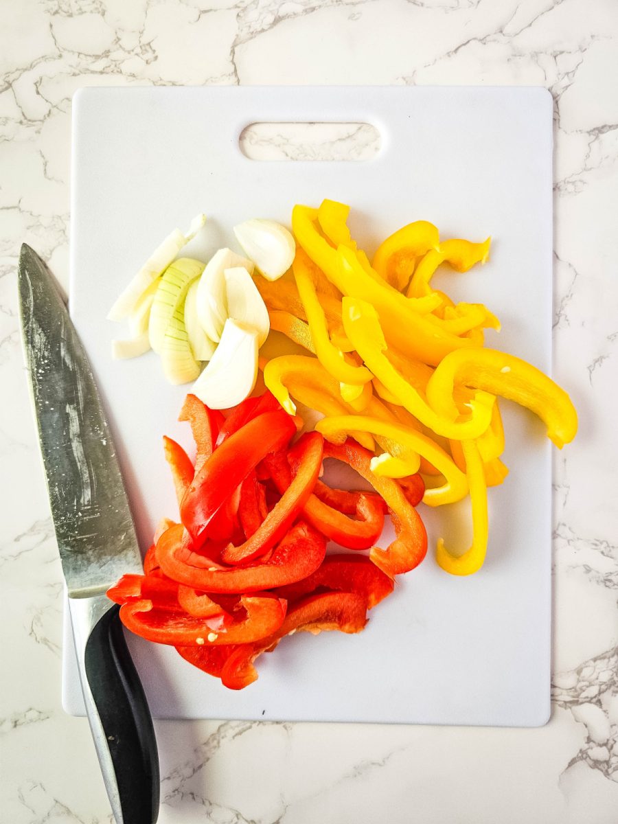 sliced onion and bell peppers on cutting board