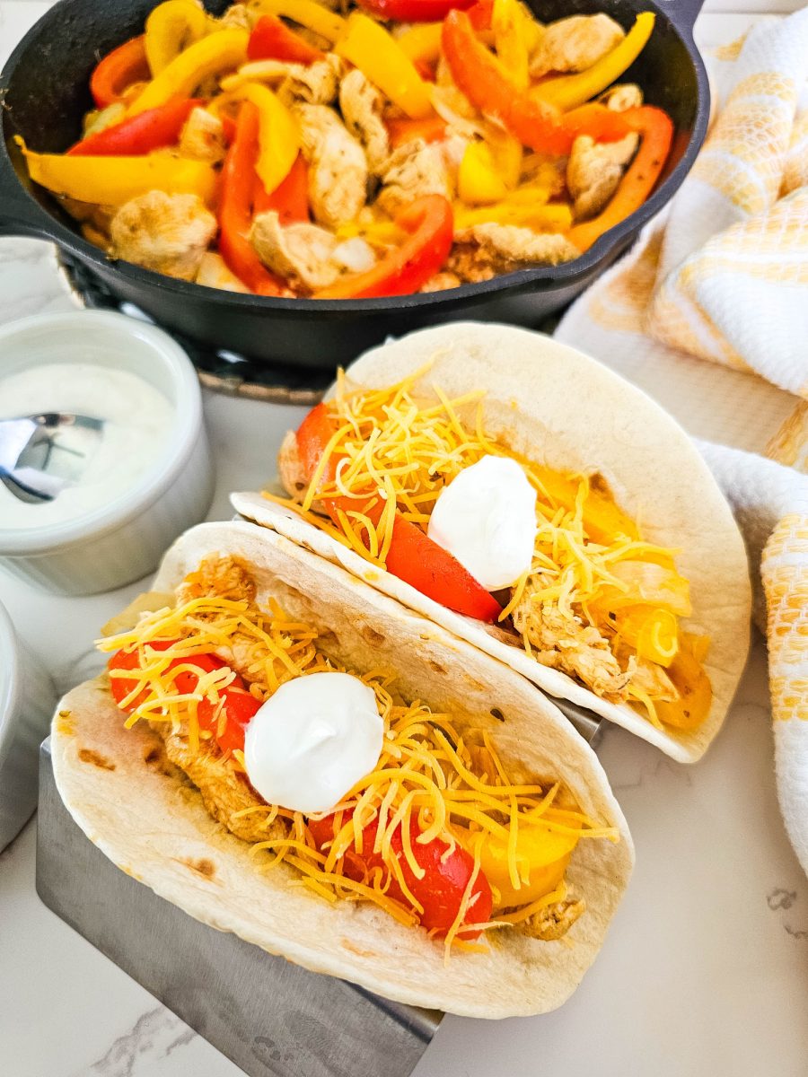 two fajitas with cheese and sour cream