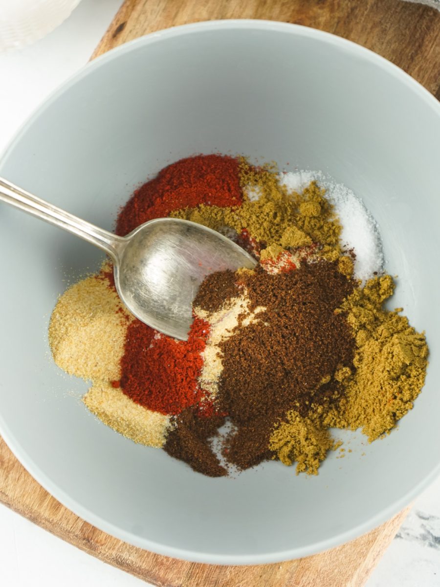 spices and herbs in bowl to combine for fajita seasoning