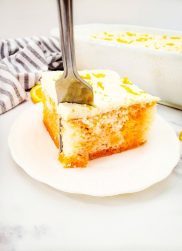 fork cutting into orange poke cake