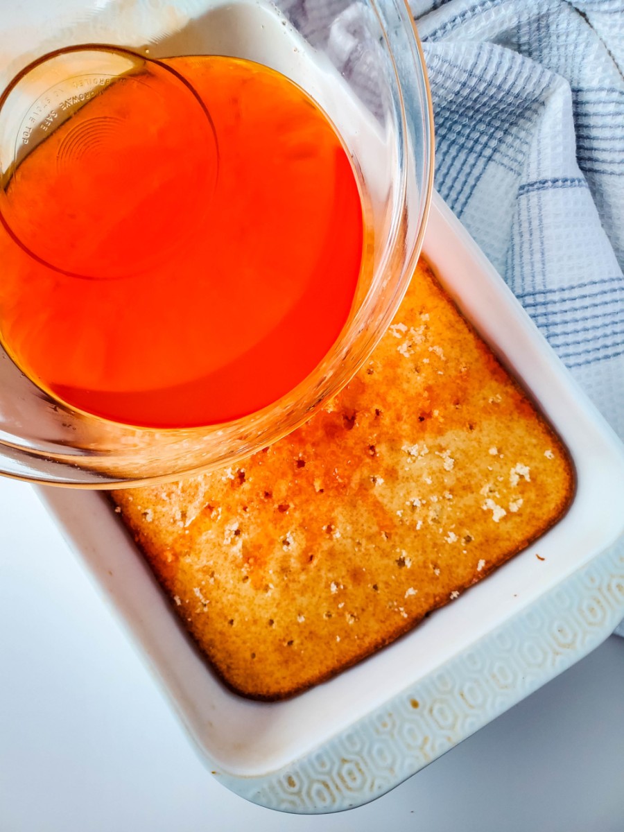 pour orange jello over cake into holes
