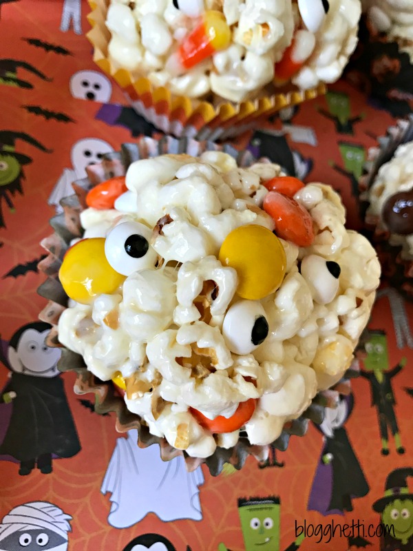 These Halloween Popcorn Balls are a great Halloween treat. It's a simple marshmallow popcorn recipe filled with candy corn and Reese's Pieces with the perfect amount of gooeyness and sweetness. The candy corn and Reese's Pieces add the perfect Halloween colors, too.