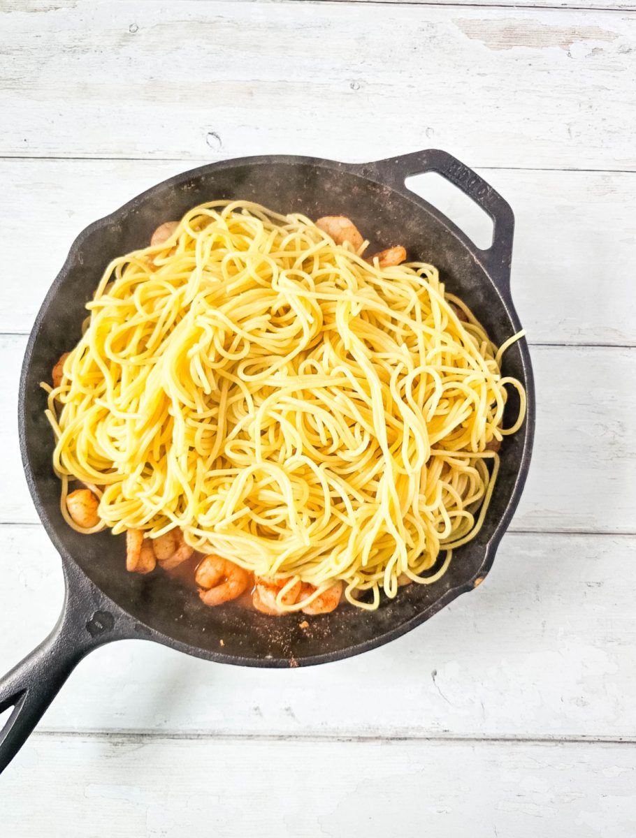 add cooked pasta to skillet with shrimp