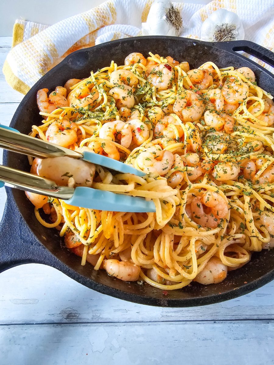 serving tongs with pasta from skillet