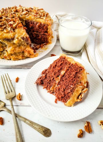 slice of German Chocolate Cake on white plate with glass of milk in background