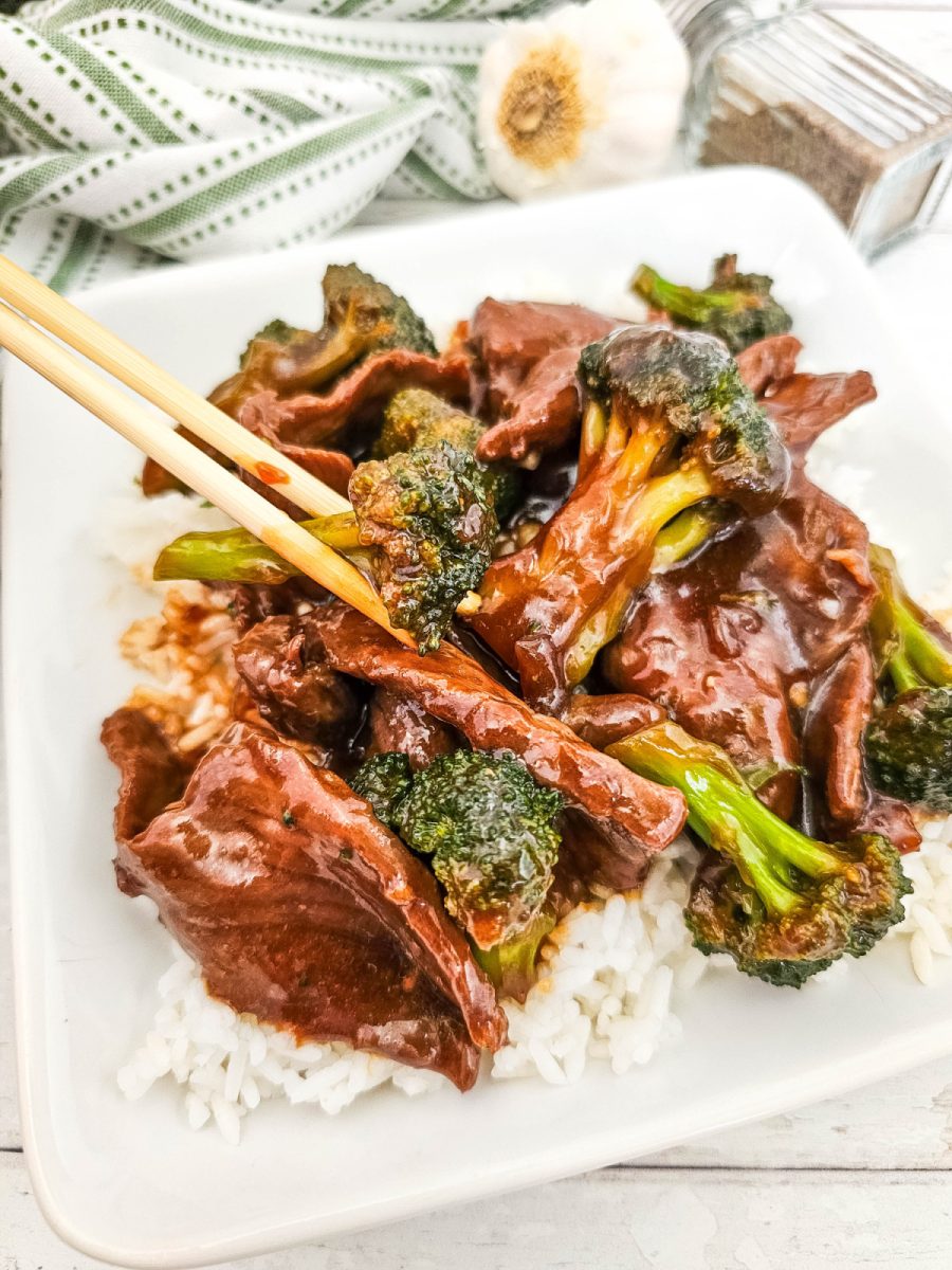 chopsticks and beef with broccoli on plate