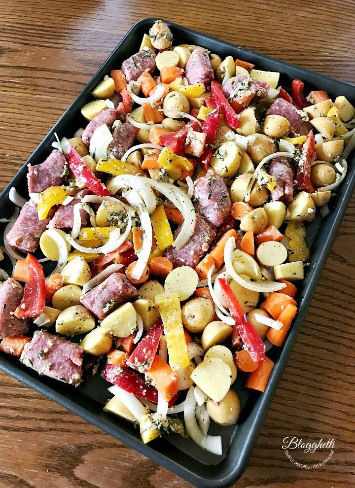 sheet pan with sausage and vegetables ready to roast