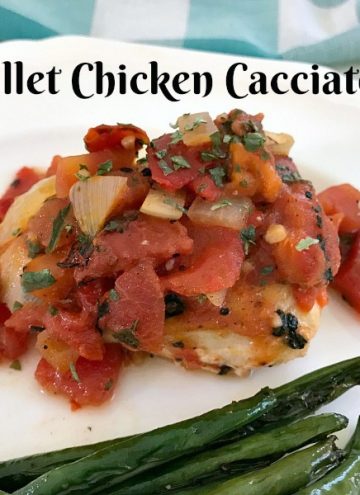 White plate with a serving of skillet chicken Cacciatore with roasted green beans