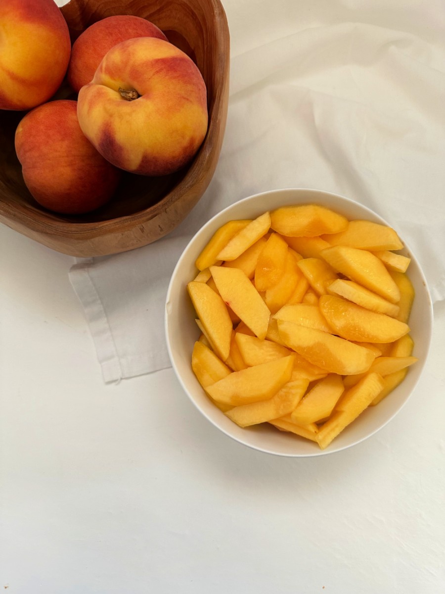 fresh peaches and bowl with peach slices