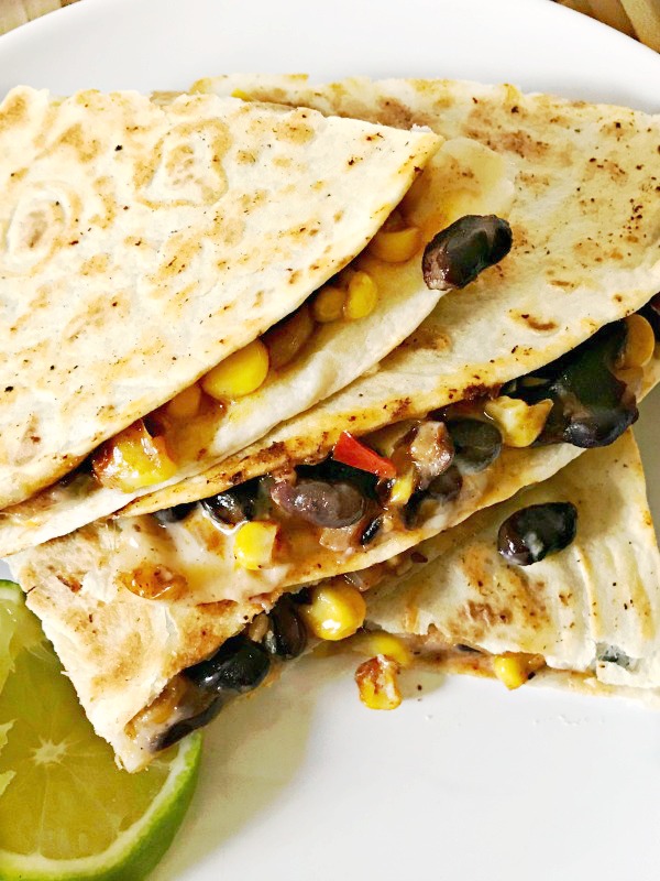Black Bean and Roasted Corn Quesadillas served on a white plate with a lime slice