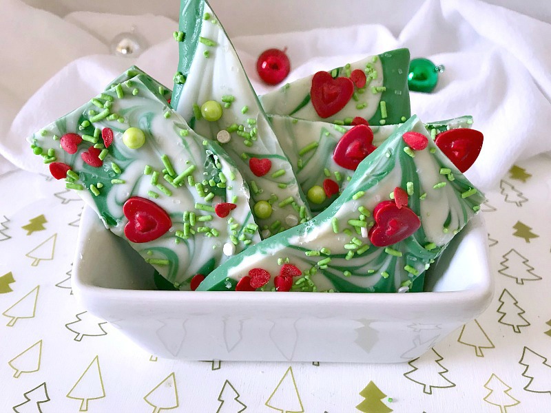 This sweet green and white chocolate candy Christmas bark will remind you of the Grinch, whose heart was two sizes too small. Perfect treat for gift giving or to satisfy a sweet tooth. #ChristmasSweetsWeek #ad #candy #grinch #candybark #srpinkles