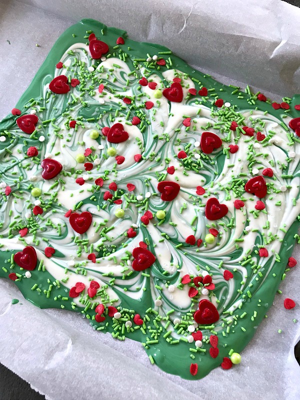 This sweet green and white chocolate candy Christmas bark will remind you of the Grinch, whose heart was two sizes too small. Perfect treat for gift giving or to satisfy a sweet tooth. #ChristmasSweetsWeek #ad #candy #grinch #candybark #srpinkles