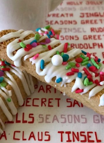 Italian Anise Biscotti gets a festive holiday makeover with colorful sprinkles. Whether you dunk this twice-baked cookies into your coffee or tea, or simply enjoy them as a treat, you'll get that classic anise flavor in each bite with bonus white chocolate drizzle. #ChristmasSweetsWeek #ad #biscotti #cookies #anise #Christmas #sprinkles