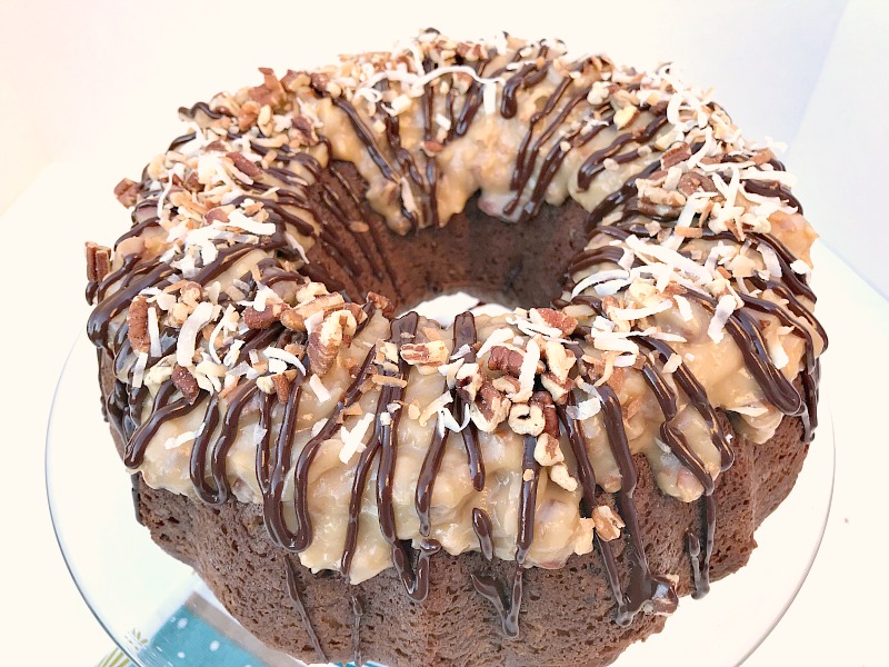 This German Chocolate Bundt Cake with a Homemade Coconut Frosting is moist, decadent, and does not disappoint. Perfect cake to celebrate any special occasion. #GermanChocolateCake #cake #chocolate