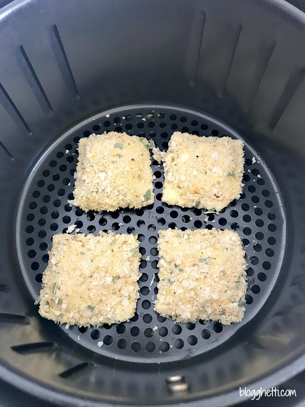 Breaded ravioli in basket of air fryer
