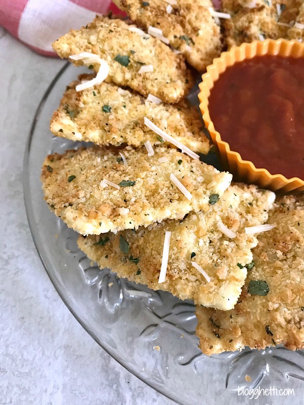 Air Fryer Fried Ravioli on a crystal plate with marinara dipping sauce.