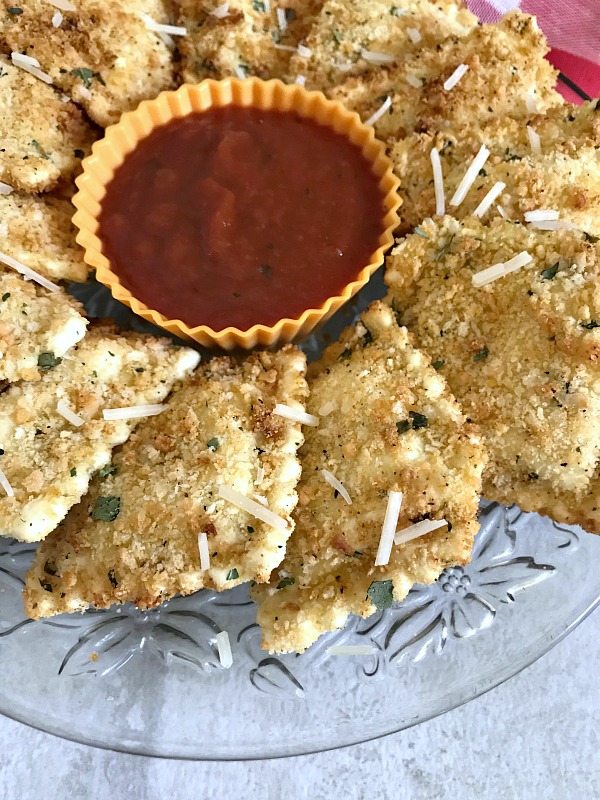 Air Fryer Fried Ravioli on a crystal plate with marinara dipping sauce,
