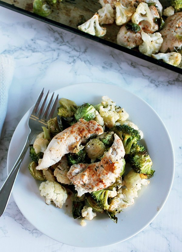 Chicken and vegetables on a white plate from a sheet pan meal