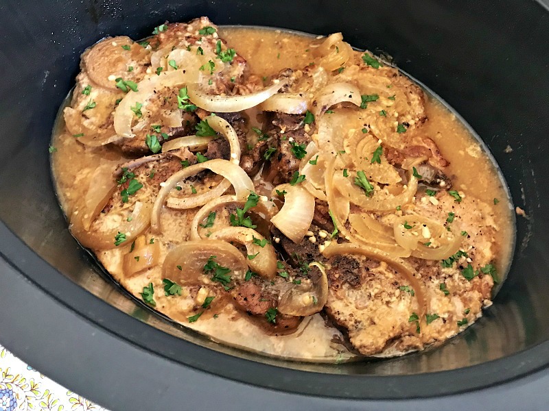 These super easy and tasty pork chops are slow cooked in a sweet and tangy sauce made from maple syrup and Dijon mustard. #porkchops #paleo #slowcooker #crockpot #maple #mustard