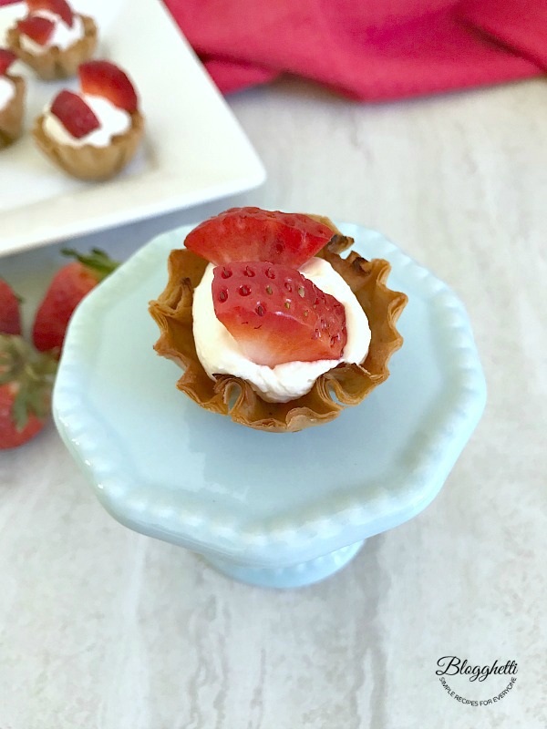 No Bake Mini Strawberry Cheesecake Cups on a small platter- close up