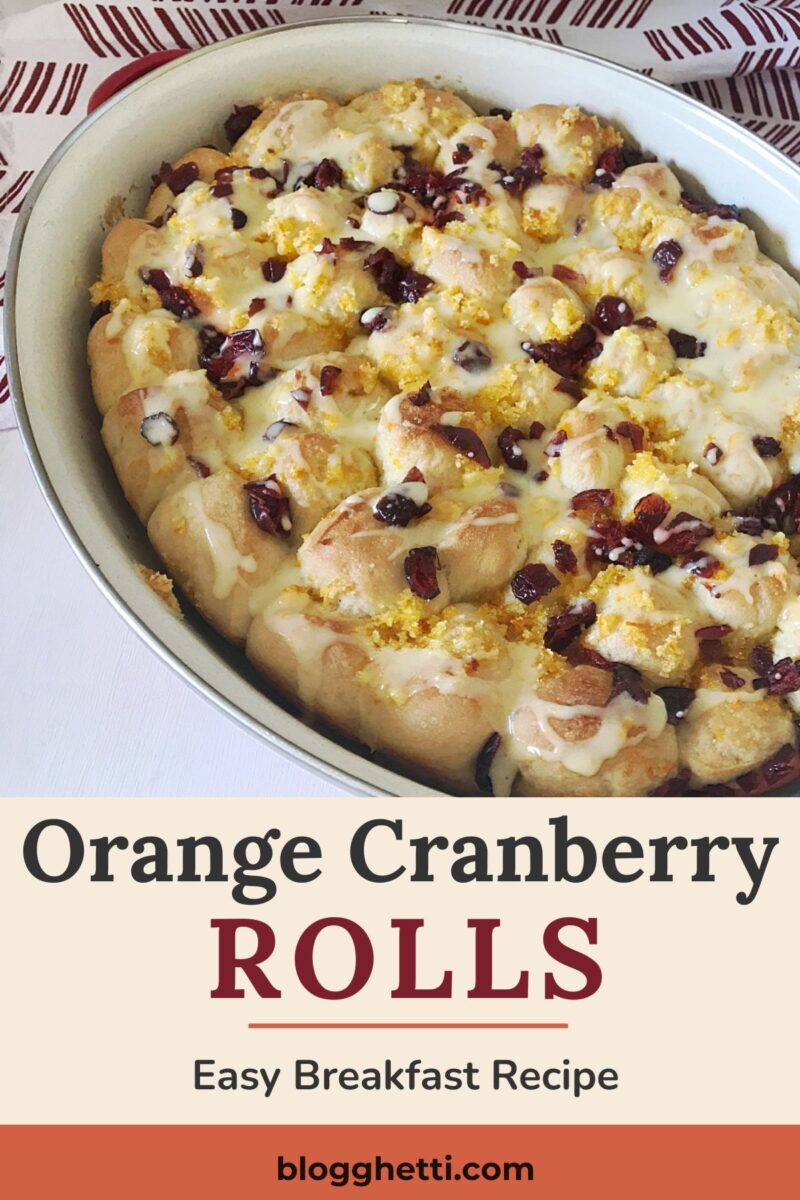 Pinterest graphic featuring a white baking dish filled with glazed orange cranberry breakfast rolls topped with dried cranberries and orange sugar. The text reads "Orange Cranberry Rolls" and "Easy Breakfast Recipe."