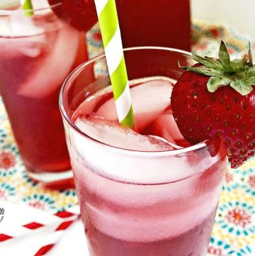 close up of Sparkling Hibiscus Iced Tea in glasses garnished with straws and strawberries. #hibiscus #icedtea #tea #drinks
